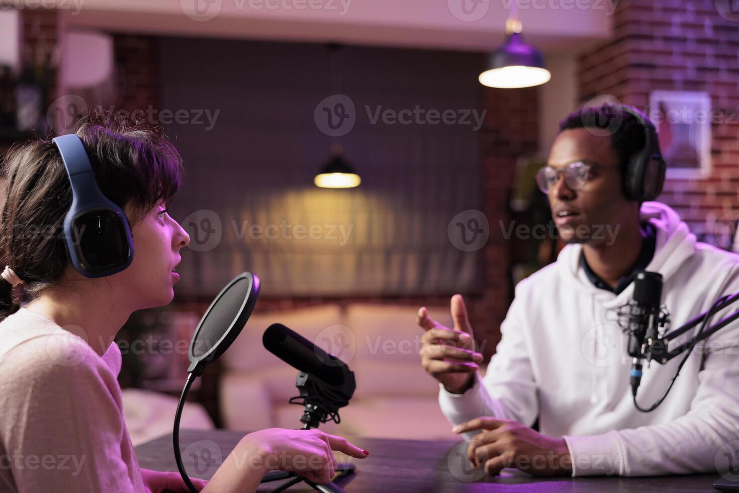 African american online show host chatting with guest during live broadcast for social media website, listening to her story. Internet celebrity using professional equipment to record podcast photo