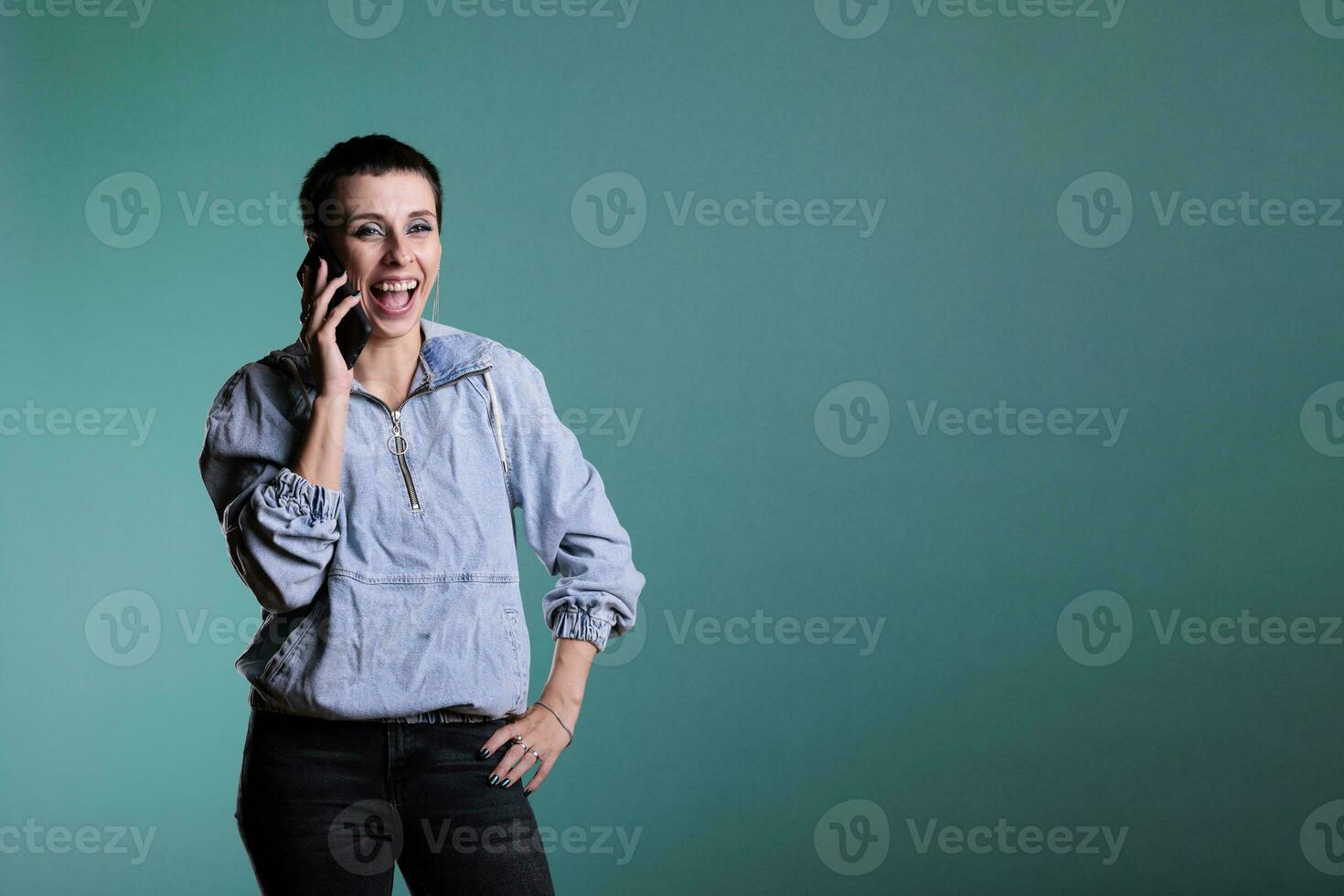 atractivo sonriente mujer con positivo facial expresión teniendo móvil teléfono conversacion con remoto amigo. alegre hembra disfrutando teléfono inteligente discusión en pie terminado aislado antecedentes foto