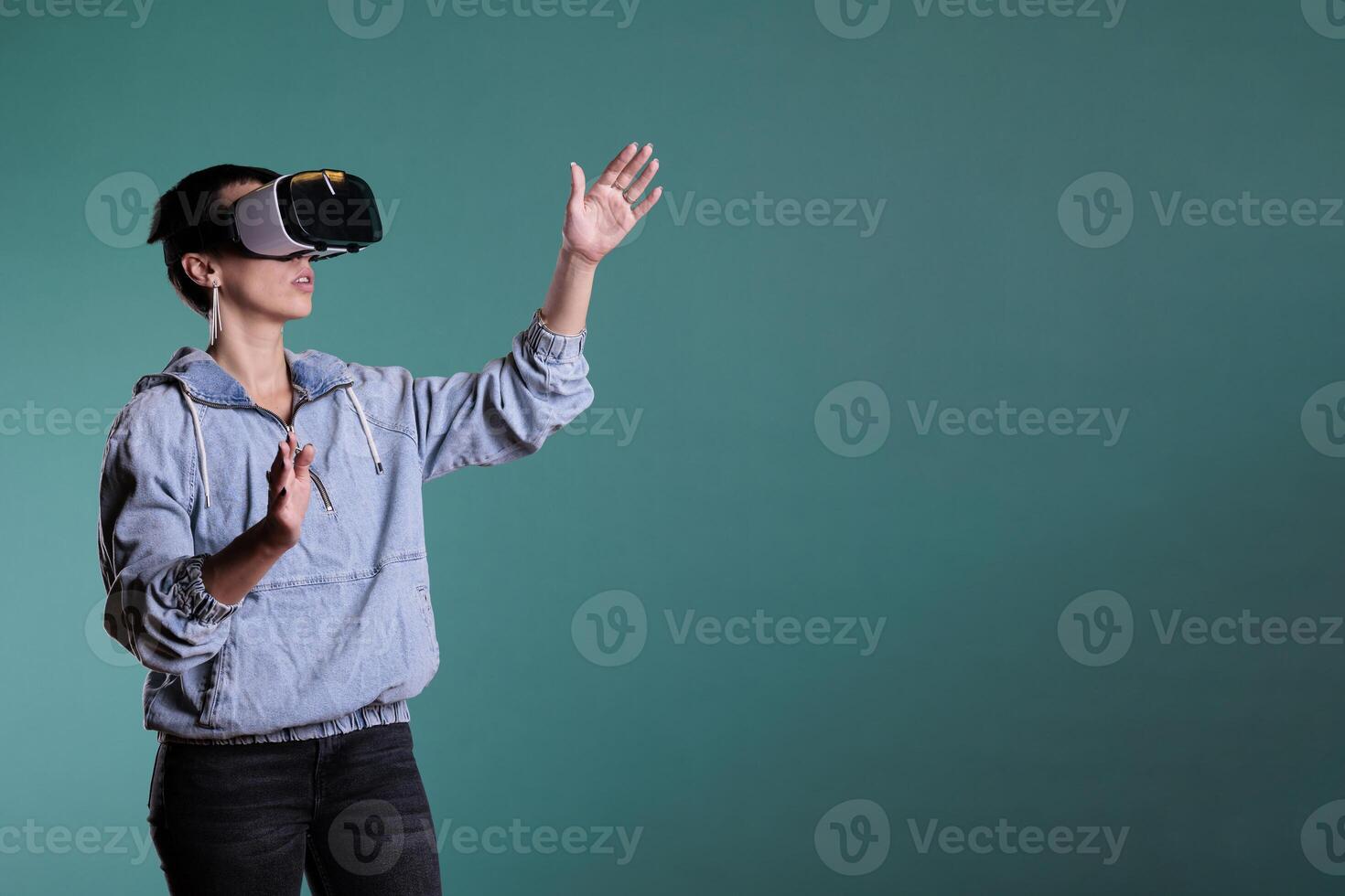 Cheerful woman wearing virtual reality headset in 3d simulation using interactive equippment. Female adult with vr goggles having futuristic experience with videogame using modern digital technology. photo