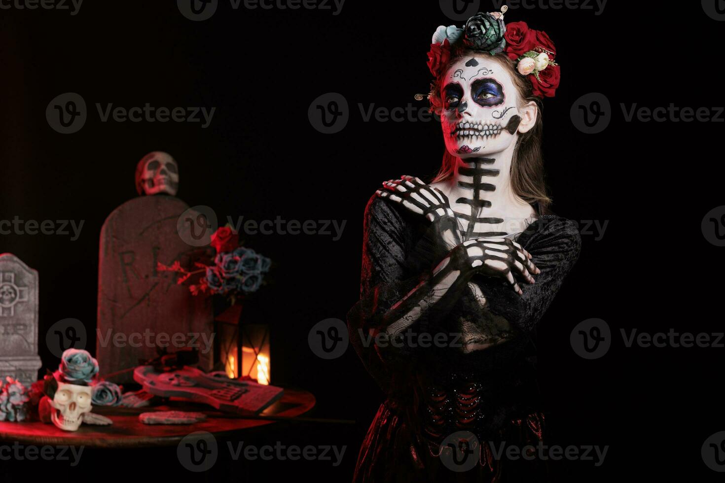 Female model posing as lady of death with flowers wreath and skull make up, wearing santa muerte black costume. Celebrating dios de los muertos with body art, festival tradition. photo