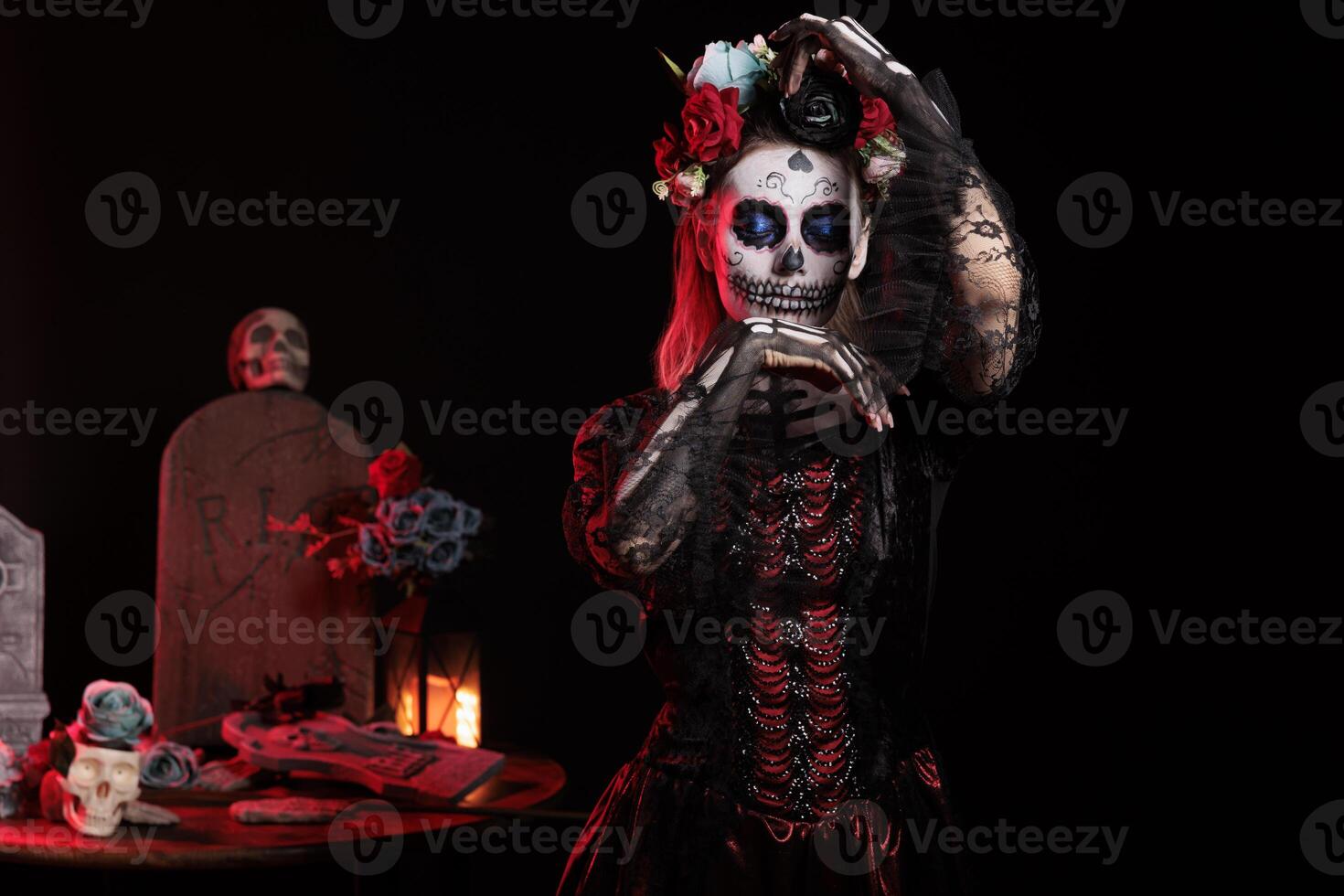 Glamorous santa muerte goddess looking like holy catrina skull in studio, posing on day of the dead holiday. Beautiful woman with black and white body art acting like lady of death. photo
