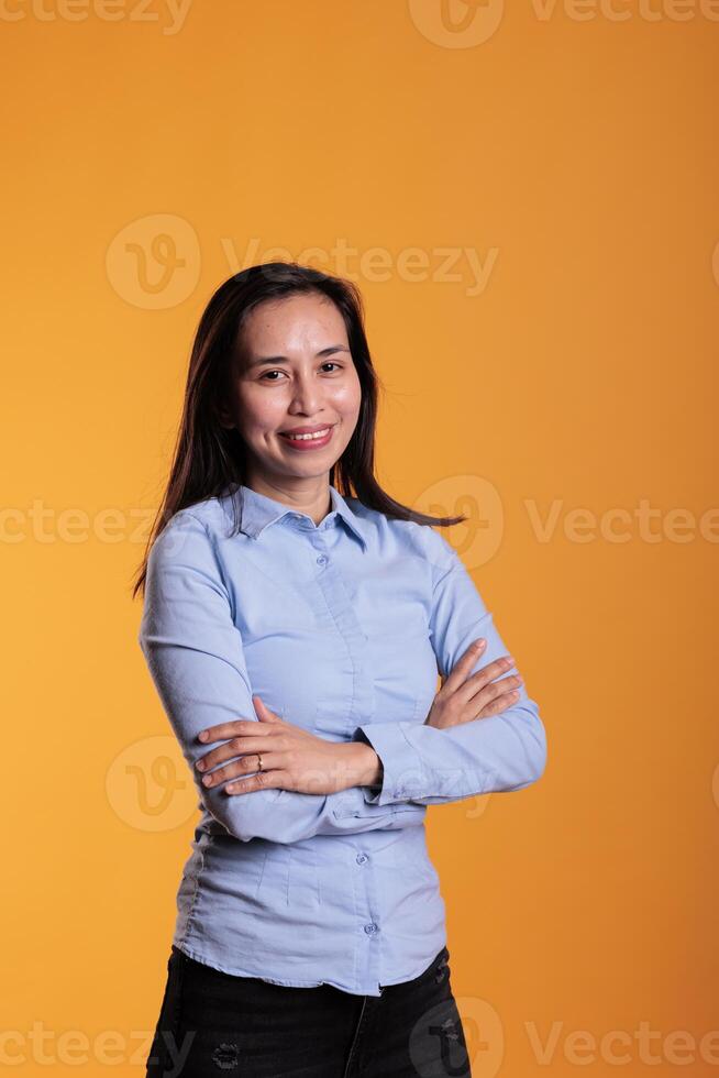 Cheerful filipino model with brunette long hair and gorgeous smiling, wearing formal during studio shot. carefree confident model having funny expression standing over yellow background photo