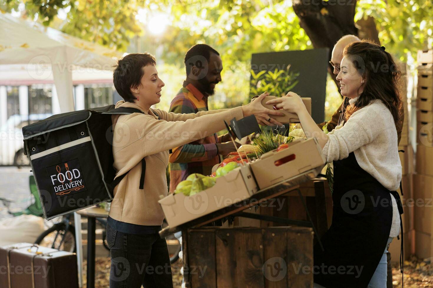 Farmers markets and home delivery. Local farmer giving box with fresh eco organic produce fruits and vegetables to female courier, delivering healthy naturally grown food to customers photo