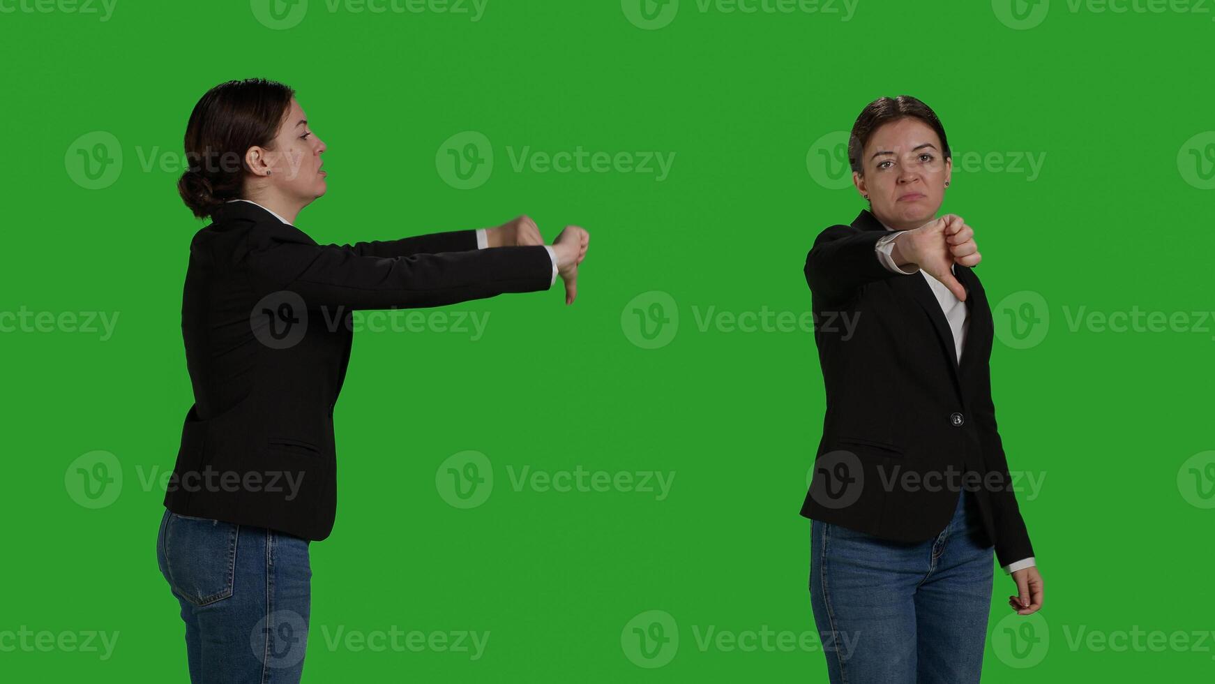 Close up of company worker doing thumbs down sign in studio, showing dislike and negative gesture. Businesswoman with office suit expressing disapproval and disagreement on camera. photo
