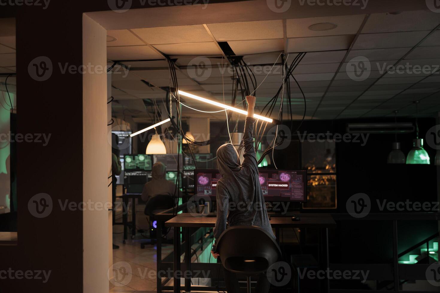 Online criminal celebrating computer system victory, successful hacking at night. Satisfied thief committing cyberattack, stealing government data and breaking into database online server. photo
