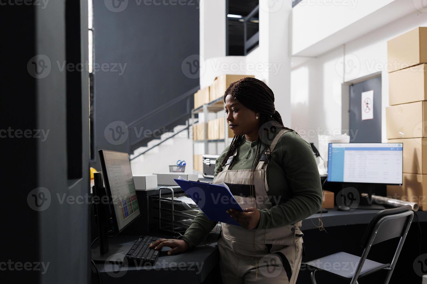 Stockroom manager working at merchandise inventory, analyzing products checklist on computer in storehouse. African american employee preparing customers orders during goods inventory photo