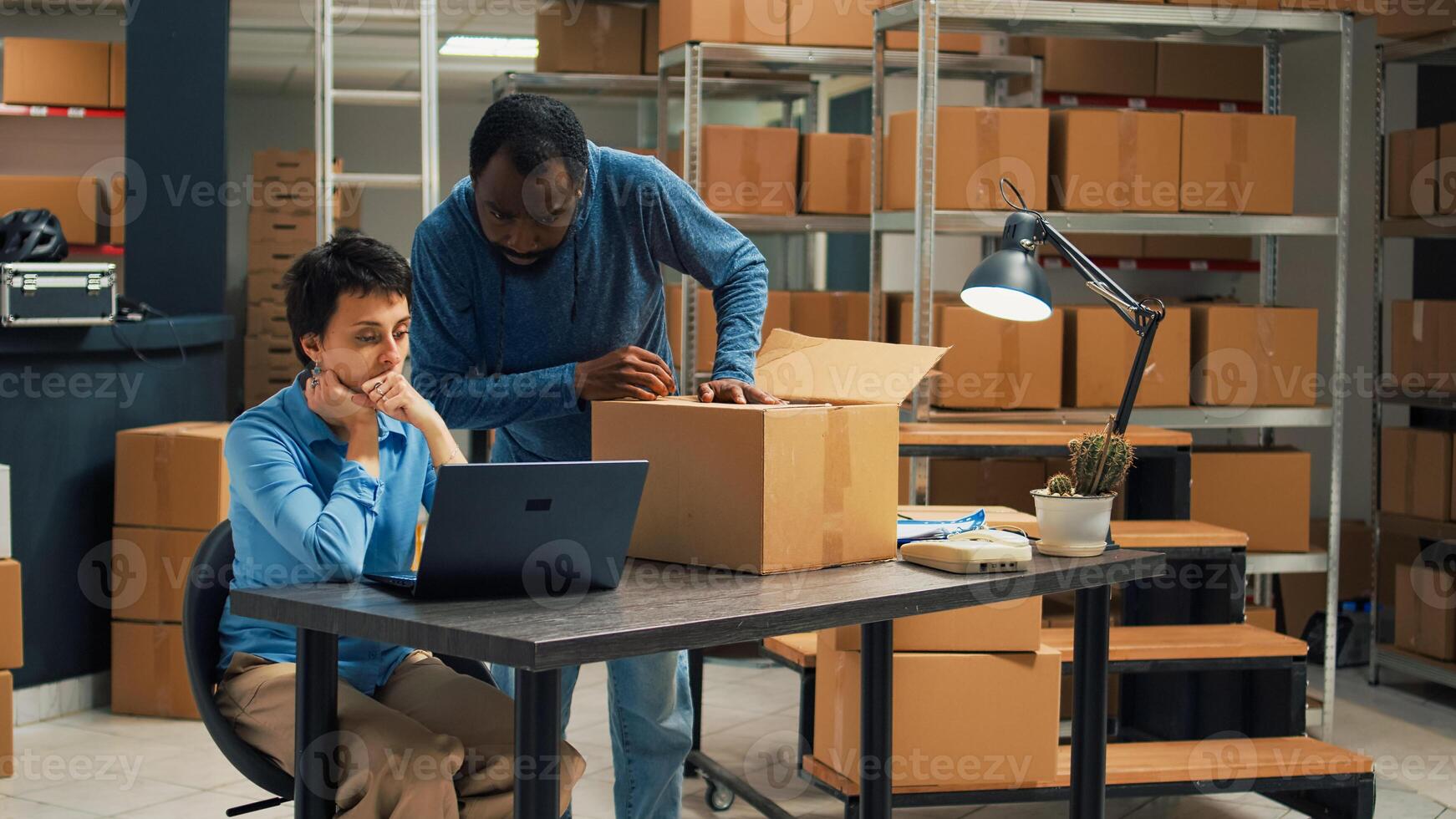 Diverse team of partners putting products in boxes and checking quality before shipping order to clients. Man and woman planning shipment with merchandise in packages, delivery logistics. photo