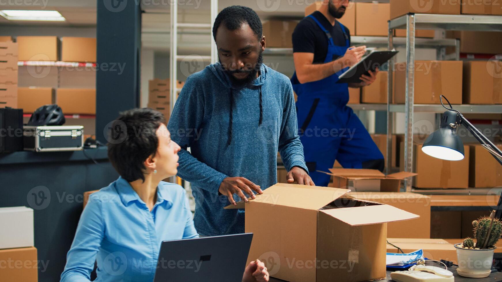 Small business owners doing quality control before shipping products order, packing merchandise in cardboard boxes. Workers preparing delivery and shipment in warehouse storage room. photo