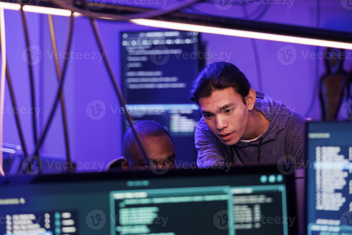 Criminals hacking into computer system while planning cyberattack and discussing phishing technique. Hackers doing ddos attack to break website and running malware code on screen photo