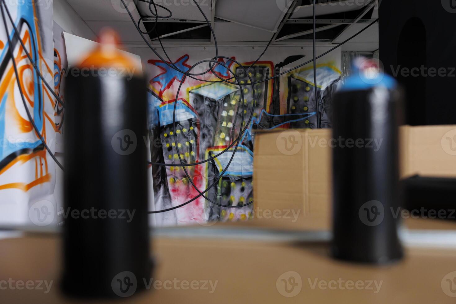 Spray paint cans used for graffiti artwork in deserted space, bottles of paint in empty neglected warehouse. Containers used for vandalism in decayed structure of abandoned building. Close up. photo