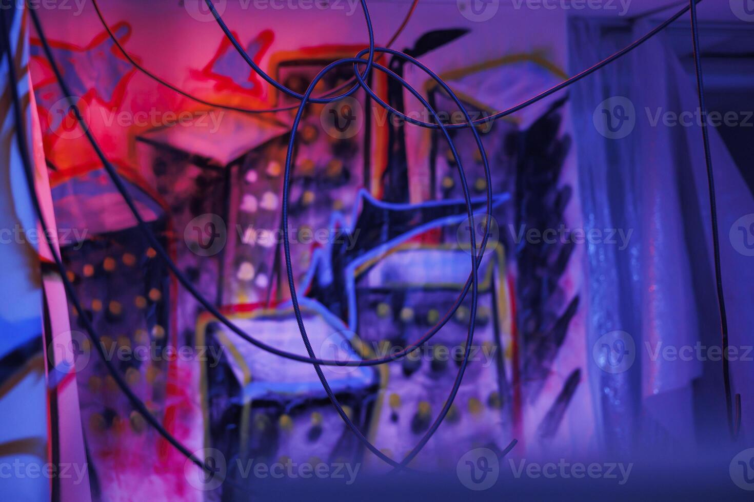 Damaged old place with fluorescent neon lights and dust on walls with graffiti art, warehouse with crumbling structure covered in messy artwork. Old abandoned space with bright lights. photo