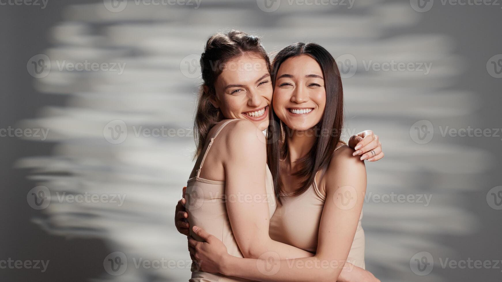 Happy diverse friends posing in studio for campaign, advertising self confidence and wellness products. Smiling girls with different skintones promoting diversity and body positivity. photo