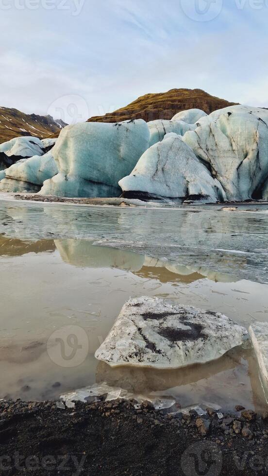 Huge ice rocks creating Vatnajokull glacier with diamond shaped in icelandic region, frozen scenery and nature. Natural arctic cracked ice fragments floating on lake, impressive icebergs. photo