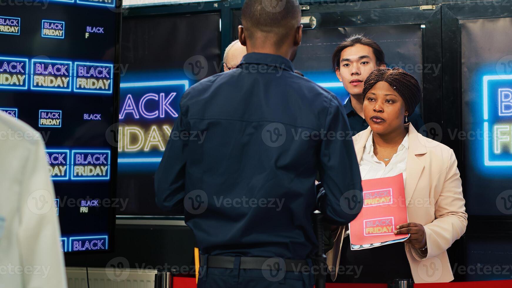 Mad diverse people in line on black friday seasonal sales, arguing with security agent to allow access into department store. Anxious crowd of clients forcing to enter shopping center. Tripod shot. photo