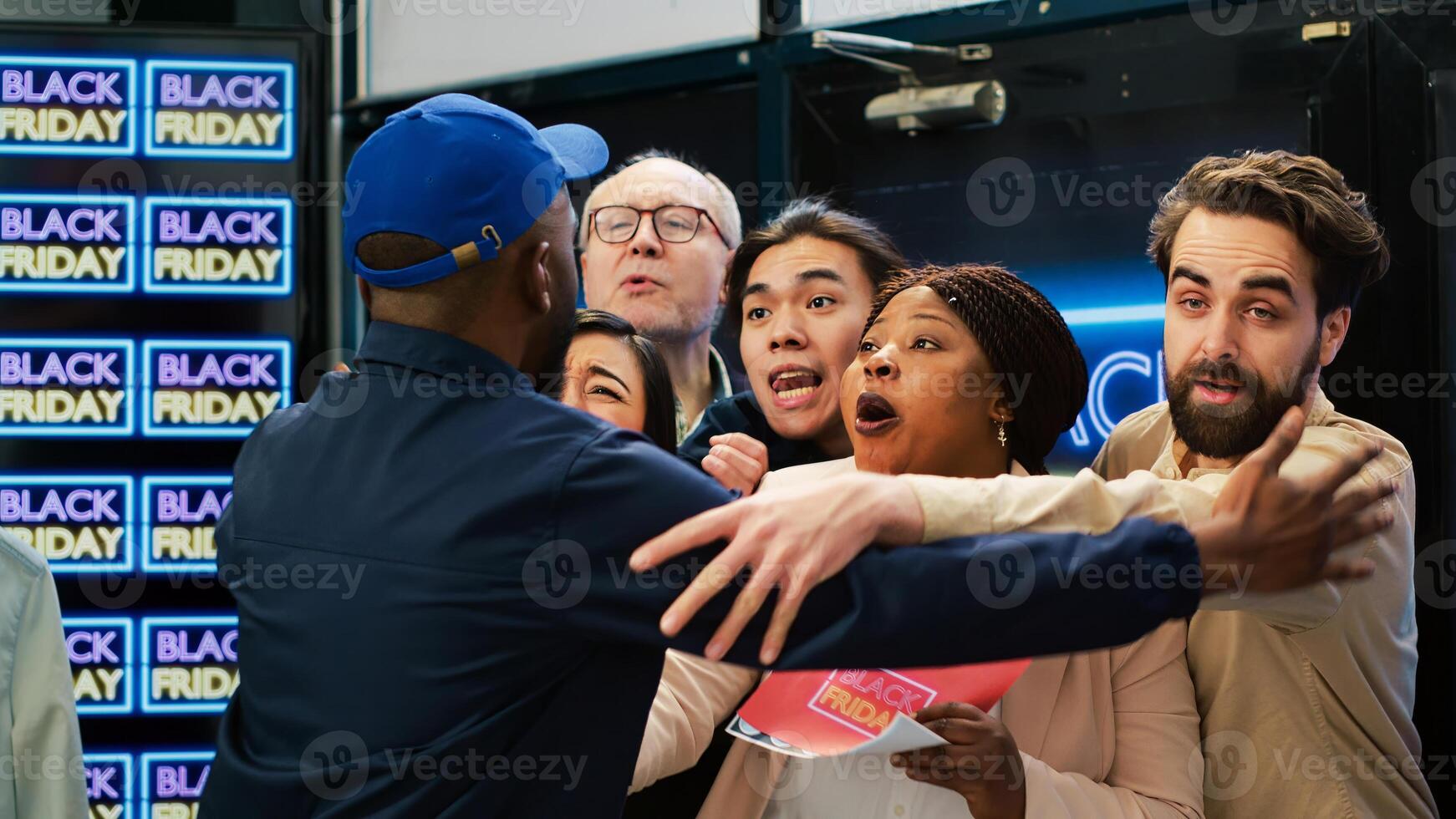 Black friday shoppers breaking red tape and pushing security guard to enter first in clothing store, enjoy promotional prices. Diverse people eager to start shopping on sale. Handheld shot. photo