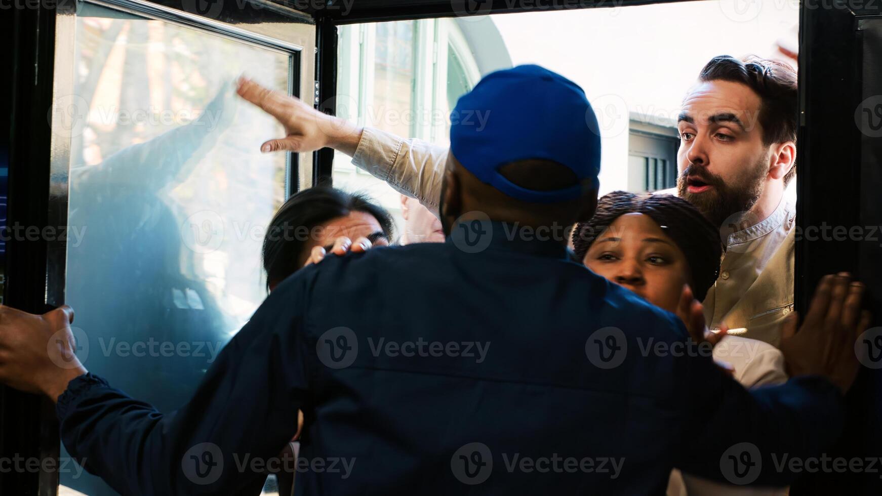 Security officer holding back clients at door entrance on black friday, trying to enter clothing store at mall. Anxious mad people searching for special offers and half price clothes. Handheld shot. photo