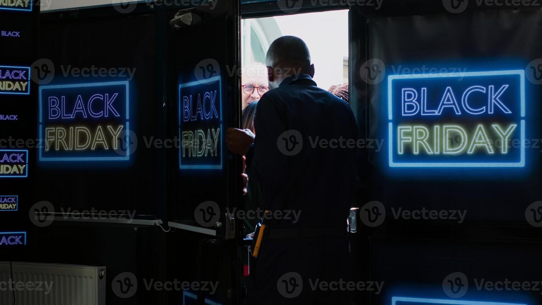 Crowd going crazy for black friday deals. Shopping center security guard managing crowd control, pushing back anxious people trying to enter fashion outlet on seasonal sales event. photo