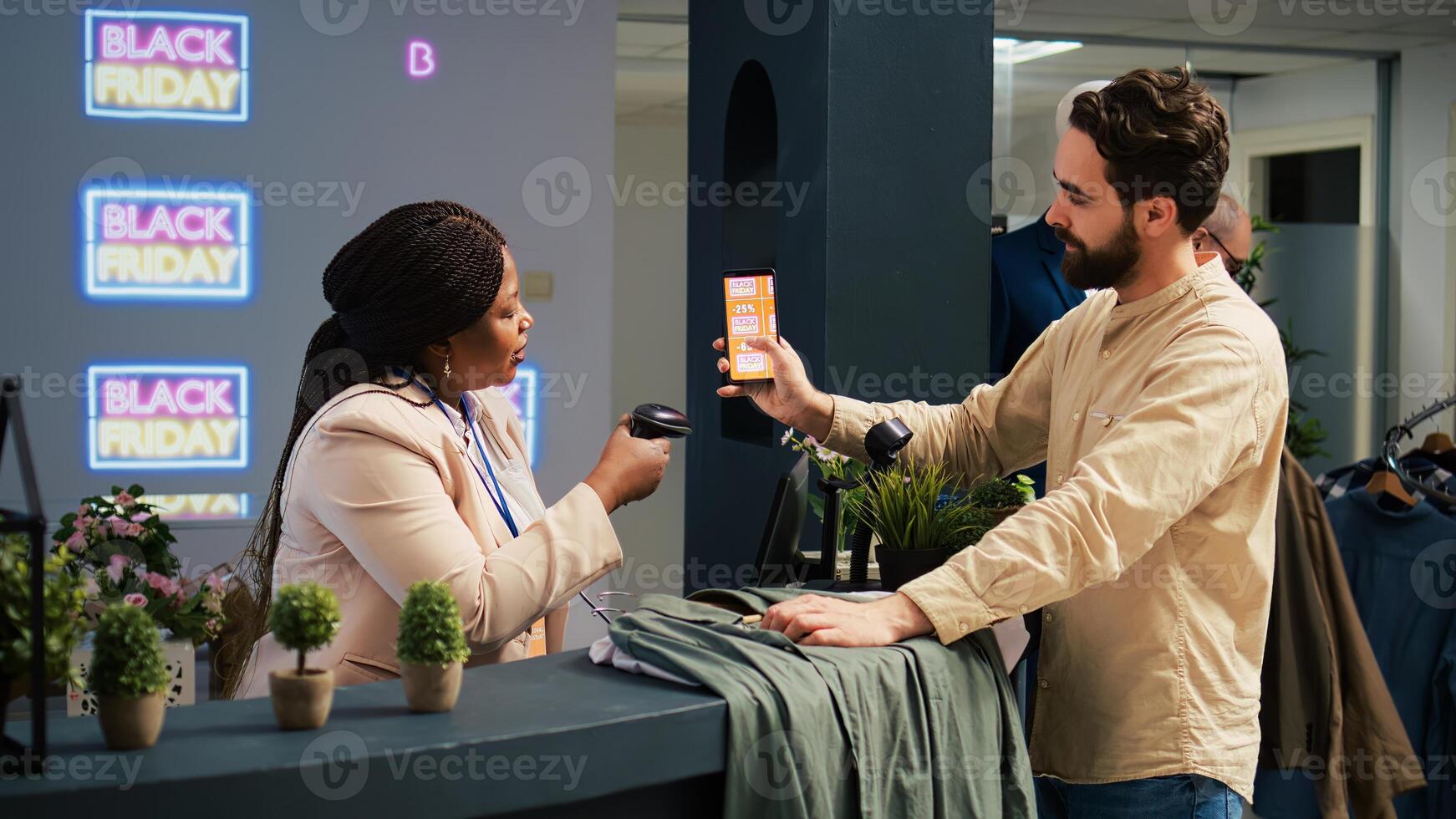 Customer using loyalty program app while standing at checkout cashier counter in shopping center duruing black friday sales. Client buying products, paying with discount voucher. photo