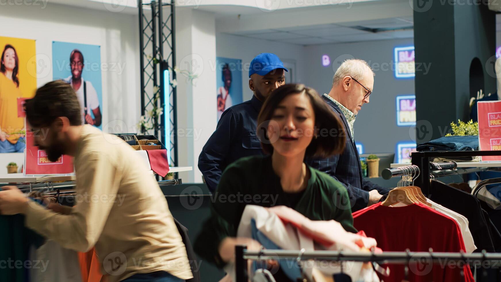 Shoppers running around retail store on black friday, in a hurry to grab clothes cheap for sales season. Busy clothing store filled with customer rushing to get best promotions on items. photo