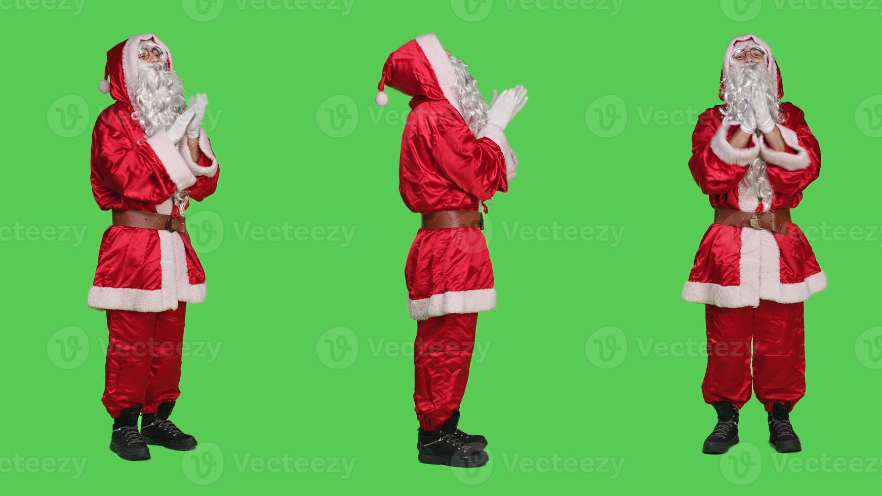Joyful character applauding on camera, cheering for something and clapping hands on greenscreen backdrop. Santa claus being happy with standing ovation gesture, traditional red costume. photo