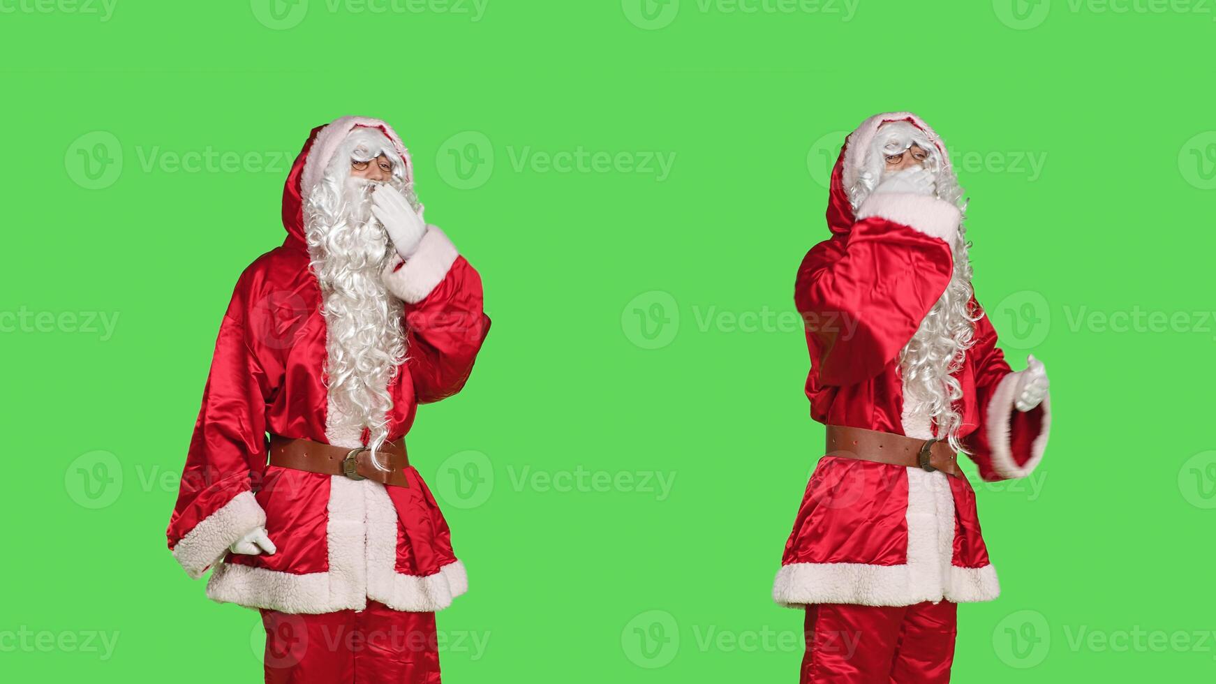 Sweet santa claus sends air kisses in studio, doing romantic gesture over greenscreen backdrop. Young man in saint nick costume acting flirty and admire people, christmas eve concept. photo