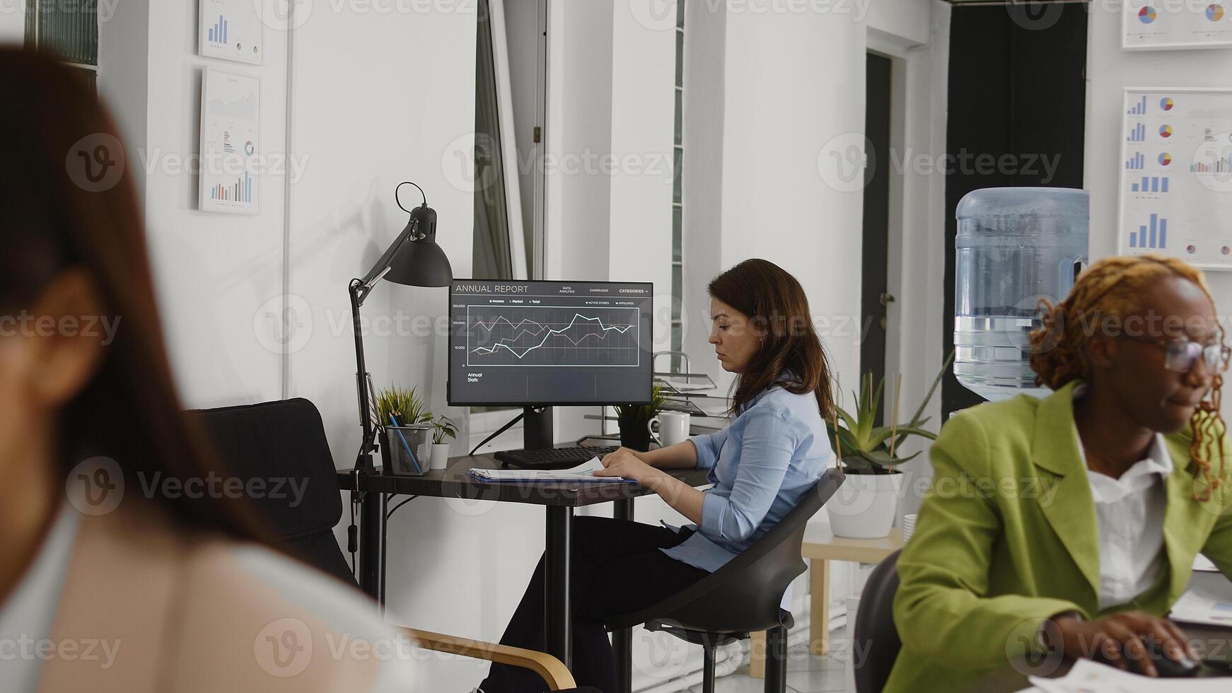 Business manager planning leadership strategy in office, looking at annual report statistics to increase profit. Young woman employee working on successful investment, company results. photo