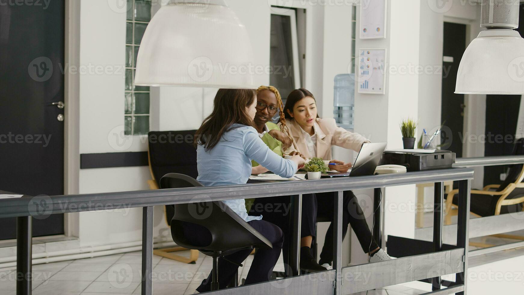 Multiethnic team of people doing collaboration in office, discussing about new development strategy and ideas. Young employees meeting in boardroom for agency investment plan. photo