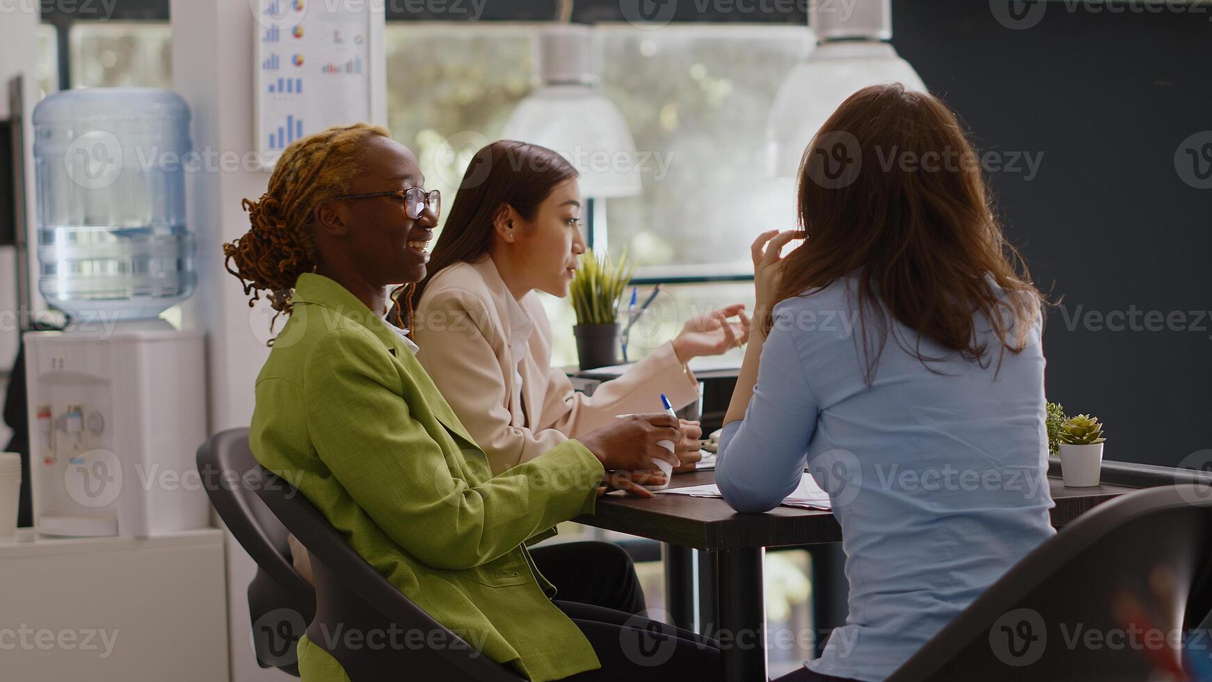 Diverse team of coworkers doing collaboration in office to plan annual report, checking online analytics on files in coworking space. Female workers discussing corporate growth. Tripod shot. photo