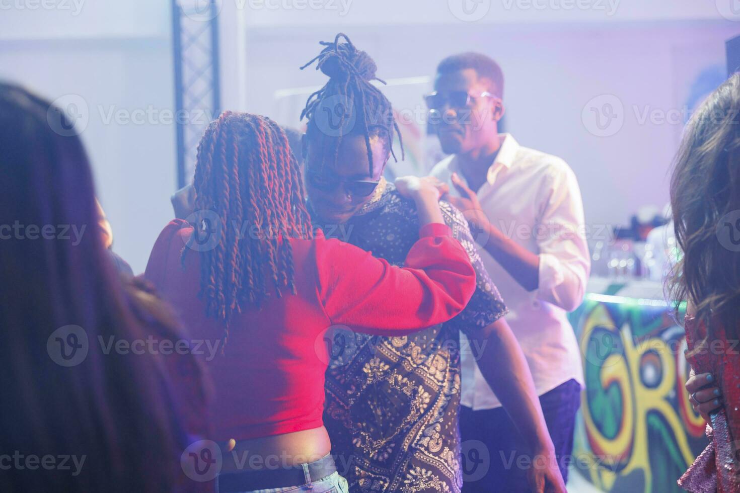 Romantic couple dancing together while partying in nightclub. African american boyfriend and girlfriend embracing, showing love and affection on dancefloor while clubbing photo