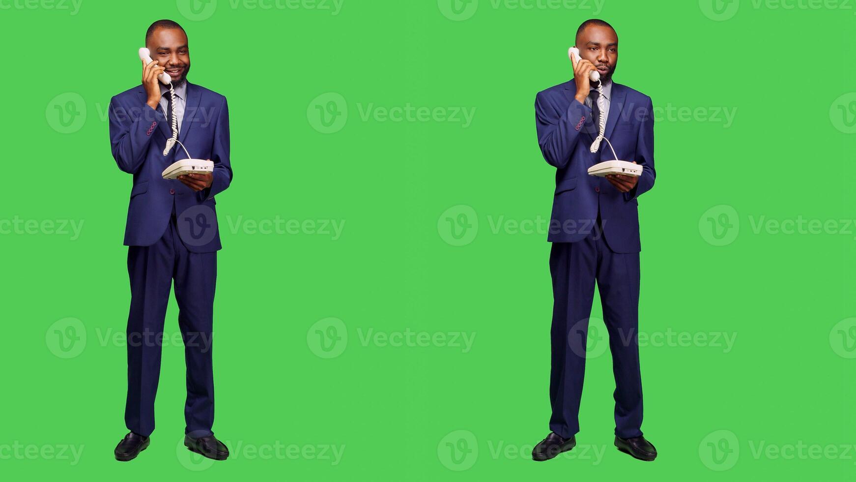 Confident employee answering landline phone call, having remote conversation on office telephone line with cord in studio. Male manager talking on phone, full body green screen. photo