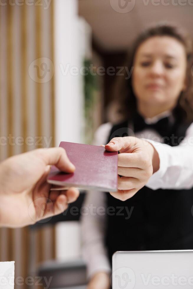 invitado da pasaporte para identificación a cheque en, Proporcionar necesario documentos a frente escritorio. empresario esperando a ver habitación reserva, de viaje en trabajo viaje. cerca arriba. foto