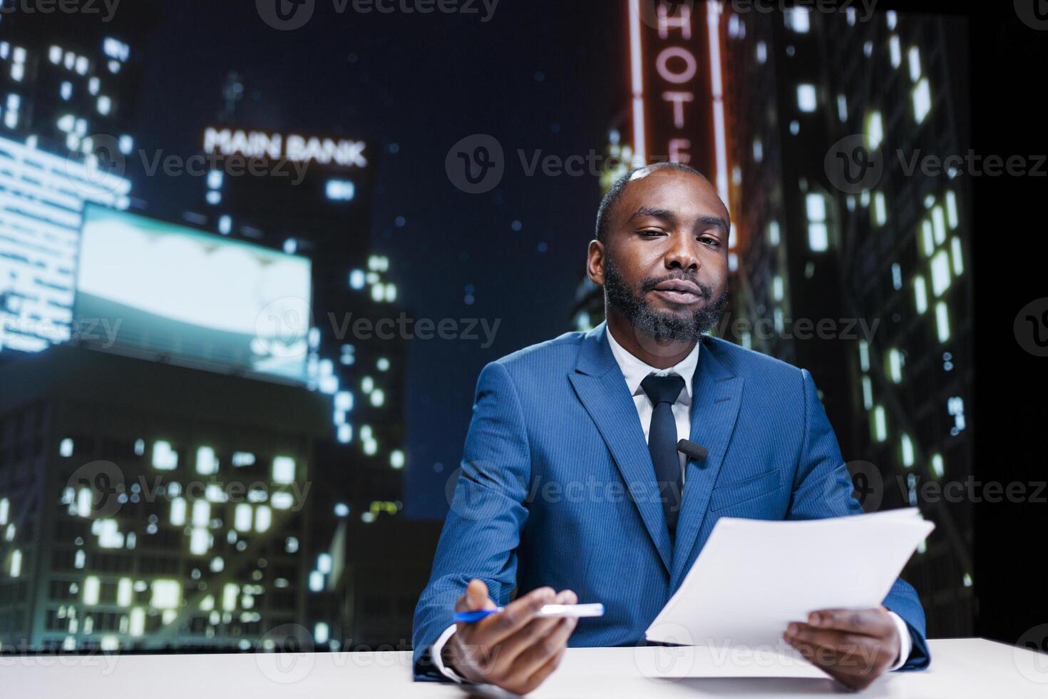 Anchorman hosting late night tv show and presenting celebrity scandals, discussing about latest important topics in newsroom. African american media presenter transmitting daily news on tv network. photo