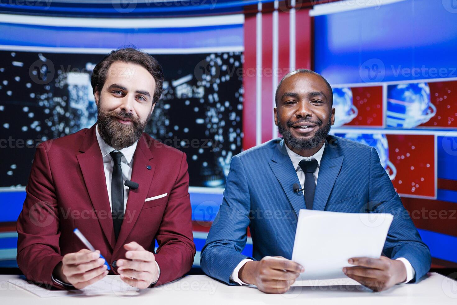 TV hosts presenting live newscast in newsroom, reporting breaking news on night talk show. Two joournalists colleagues broadcasting important events, covering relevant topics on tv network. photo