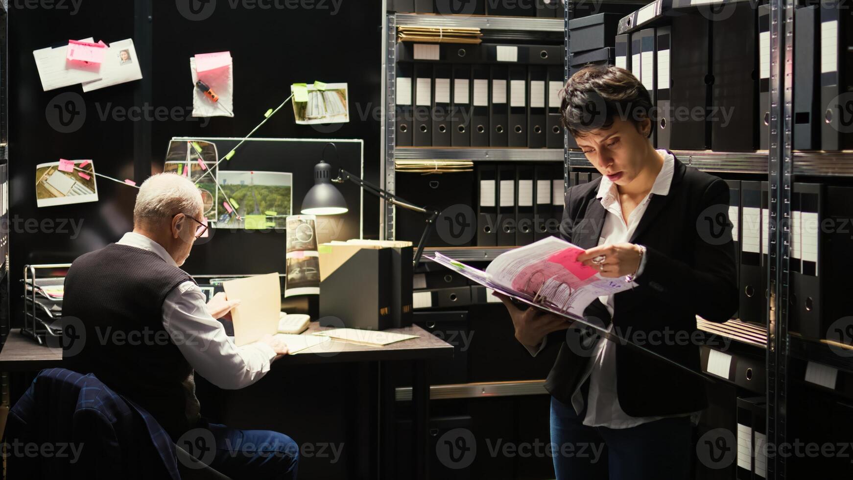 agentes hojeada mediante caso archivo, molesto a encontrar nuevo crucial información en sospechar. equipo de detectives edificio fuerte acusaciones en contra delincuente, haciendo antecedentes cheque con registros. foto