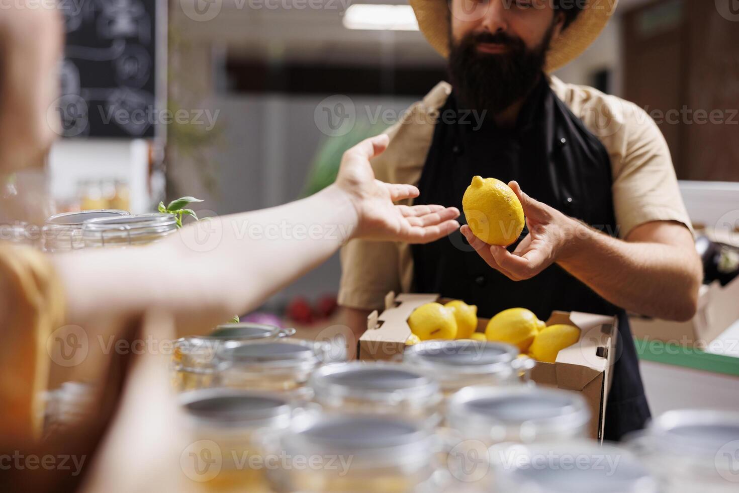 Customer in zero waste supermarket talking with shopkeeper, inquiring about freshly received batch of farm grown organic fruits. Environmentally mindful client in eco store asking for healthy products photo