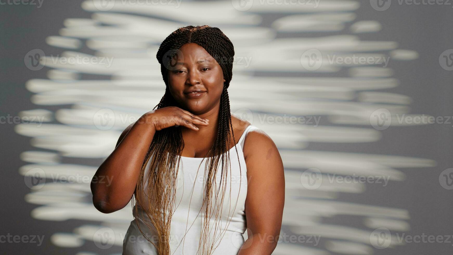 Young person embracing imperfections on camera, posing for empowering skincare ad campaign. Positive gentle woman with natural radiant skin feeling confident with body and skintone. photo