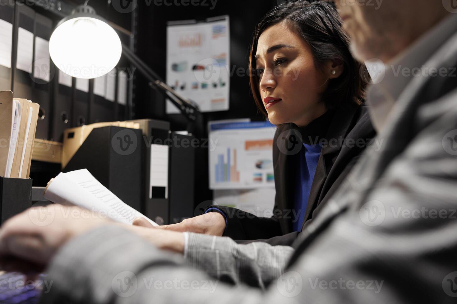 Accounting business executives coworkers imputing bookkeeping analytics data on laptop. Teamworking elderly businessman and asian collegue in administrative archival depository storage office photo