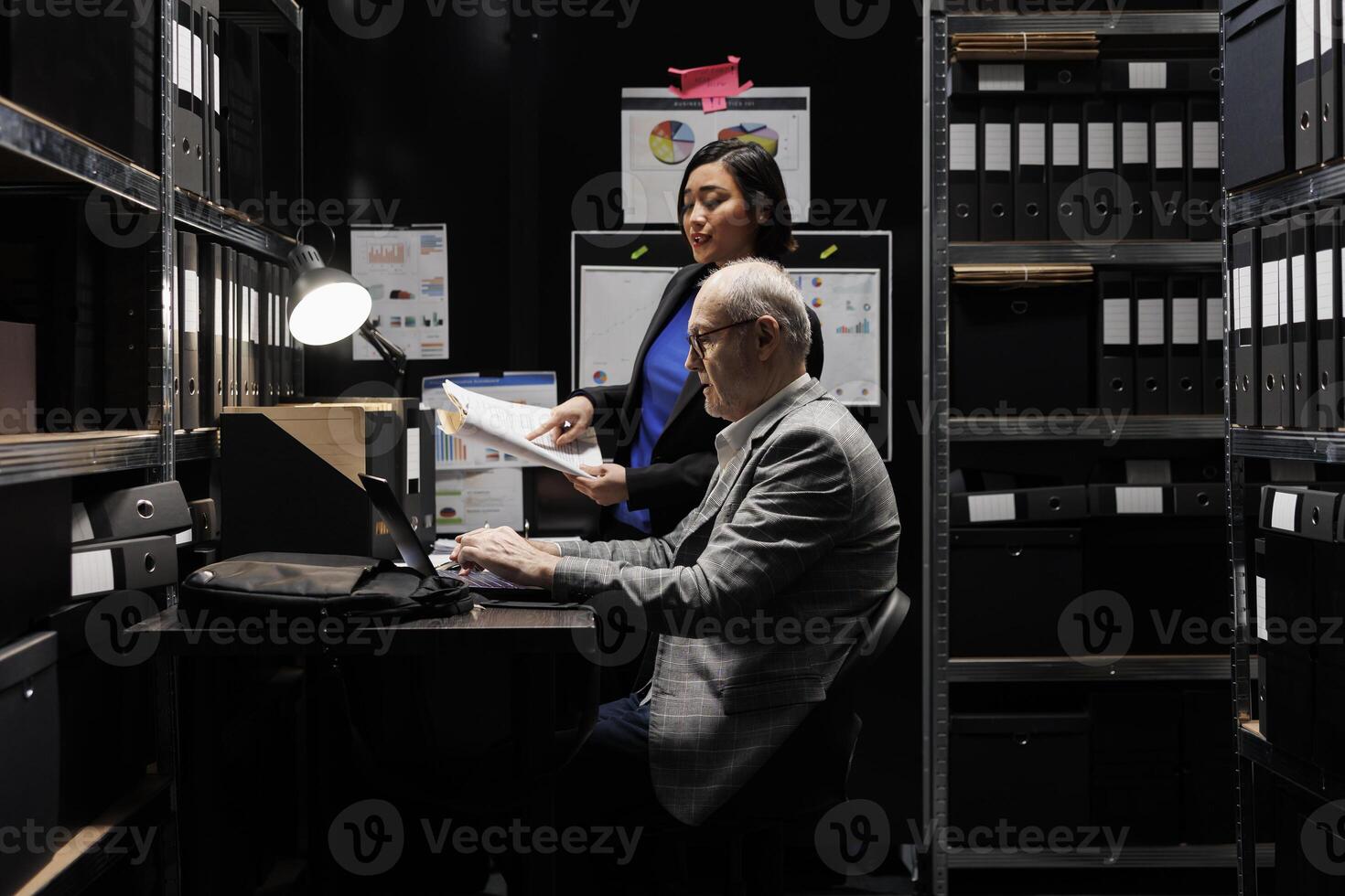Business invoicing management employees comparing accountancy market data analysis digital paperwork. Archival depository filled with folders in cabinet and graphic charts photo
