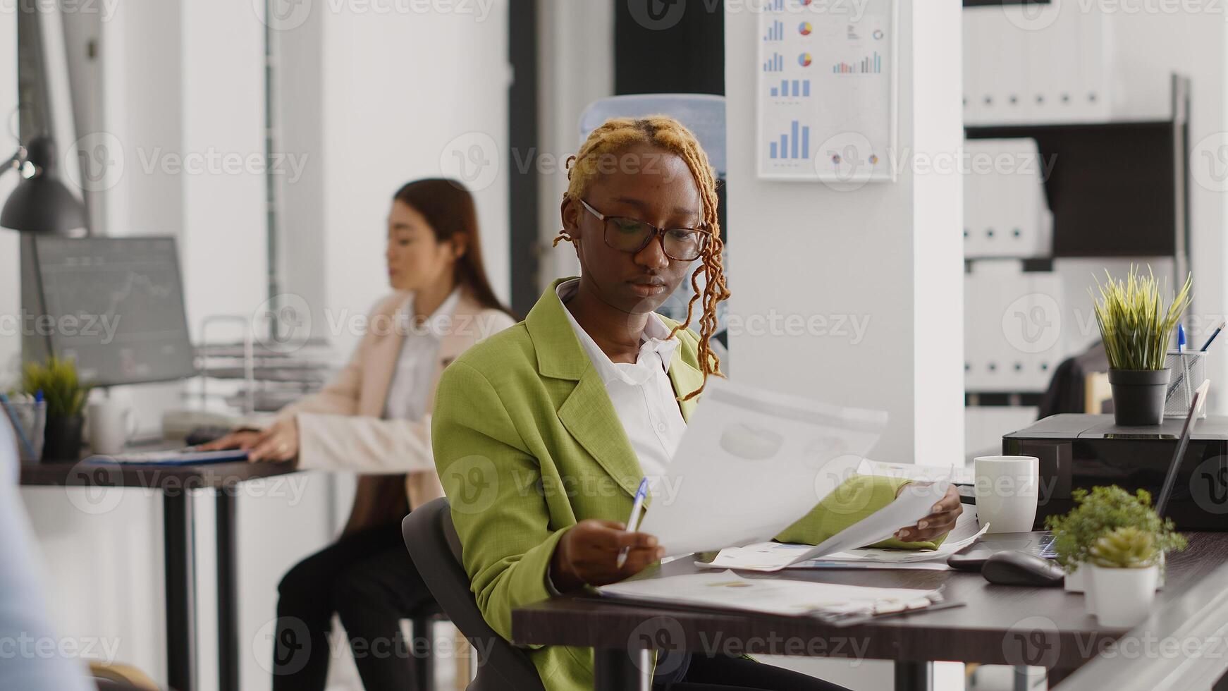 Business woman finding creative solutions at desk, writing online data on files planning new investment. Young adult checking online analytics on documents, management project. photo