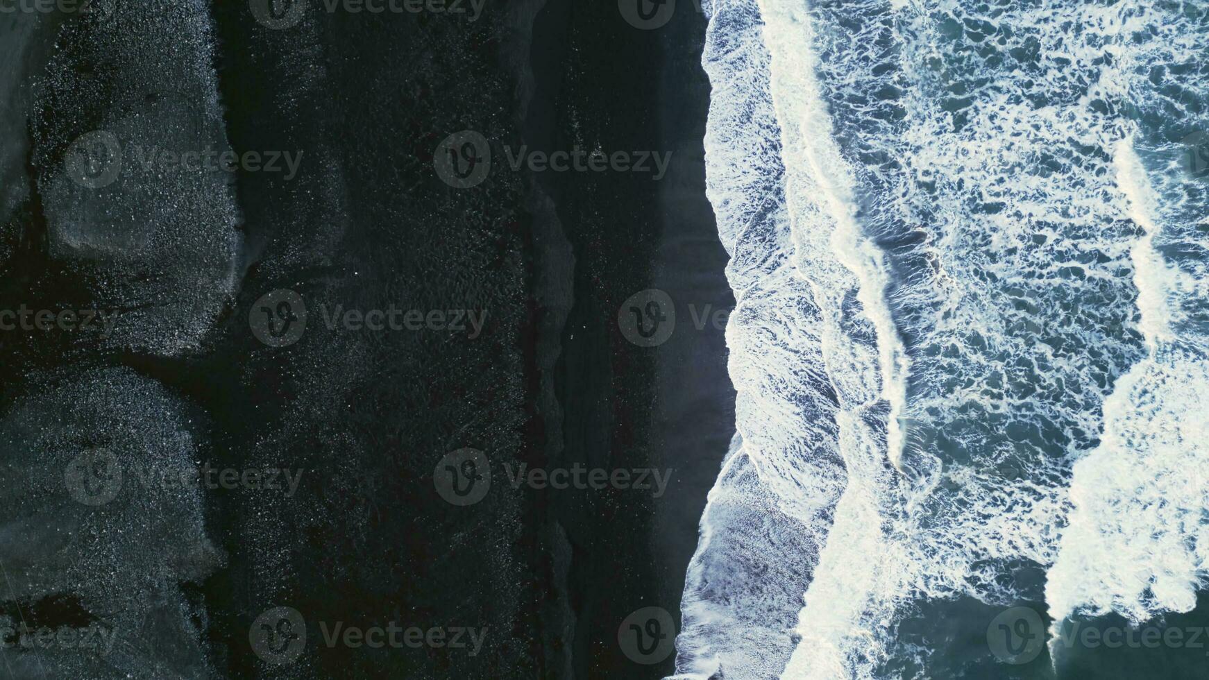 Drone shot of nordic black sand beach in iceland, majestic atlanic shore with icelandic landscape and polar scenery. Beautiful scenic route with waves crashing ocean coastline. Slow motion. photo