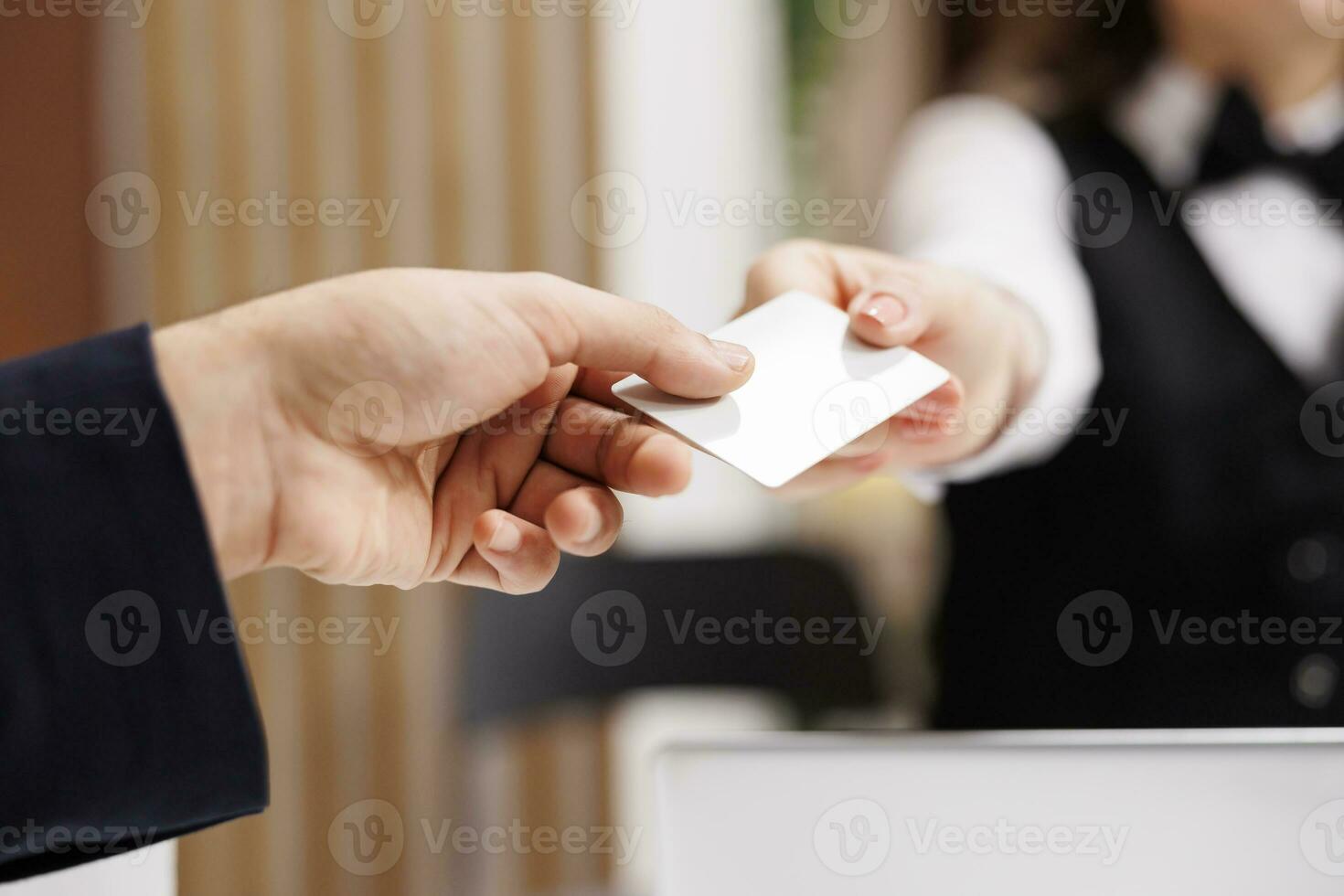 Staff handing room access card to client, white collar worker travelling on business trip. Man in suit approaching front desk to register on online booking, receive key. Close up. photo