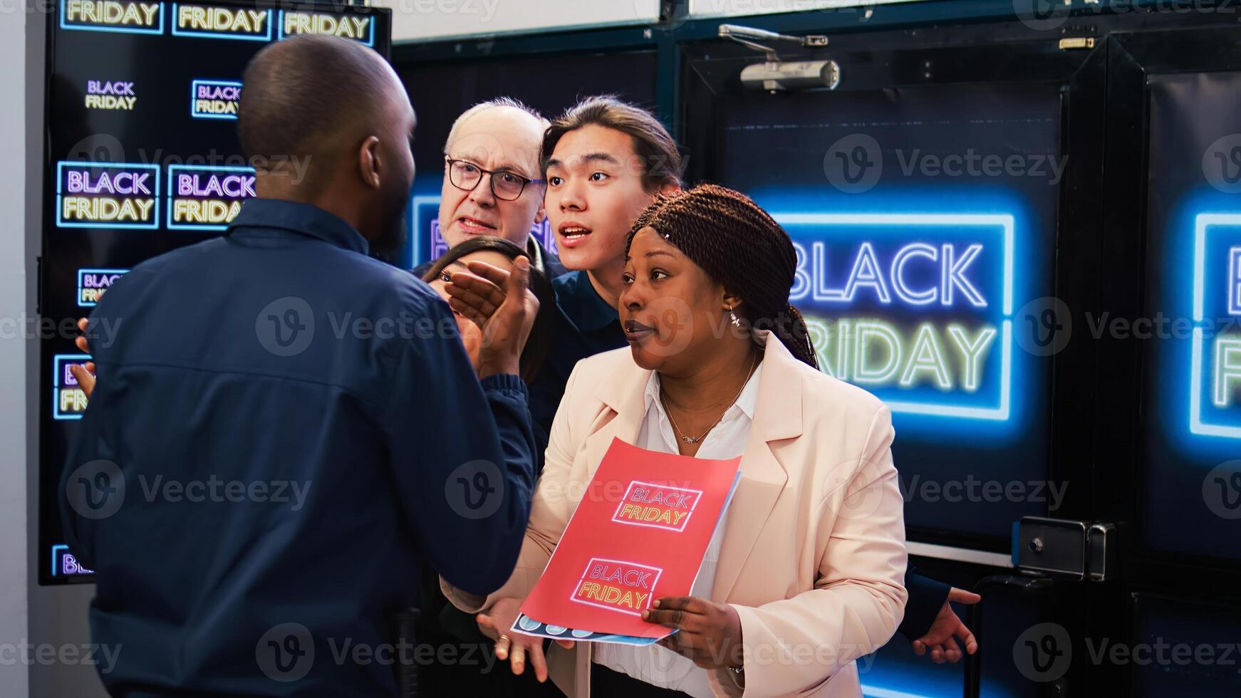 Black Friday shopping madness. Group of mad diverse clients push security guard to enter first into shopping center. Bargain hunters going crazy to get best deals, seasonal discounts. photo