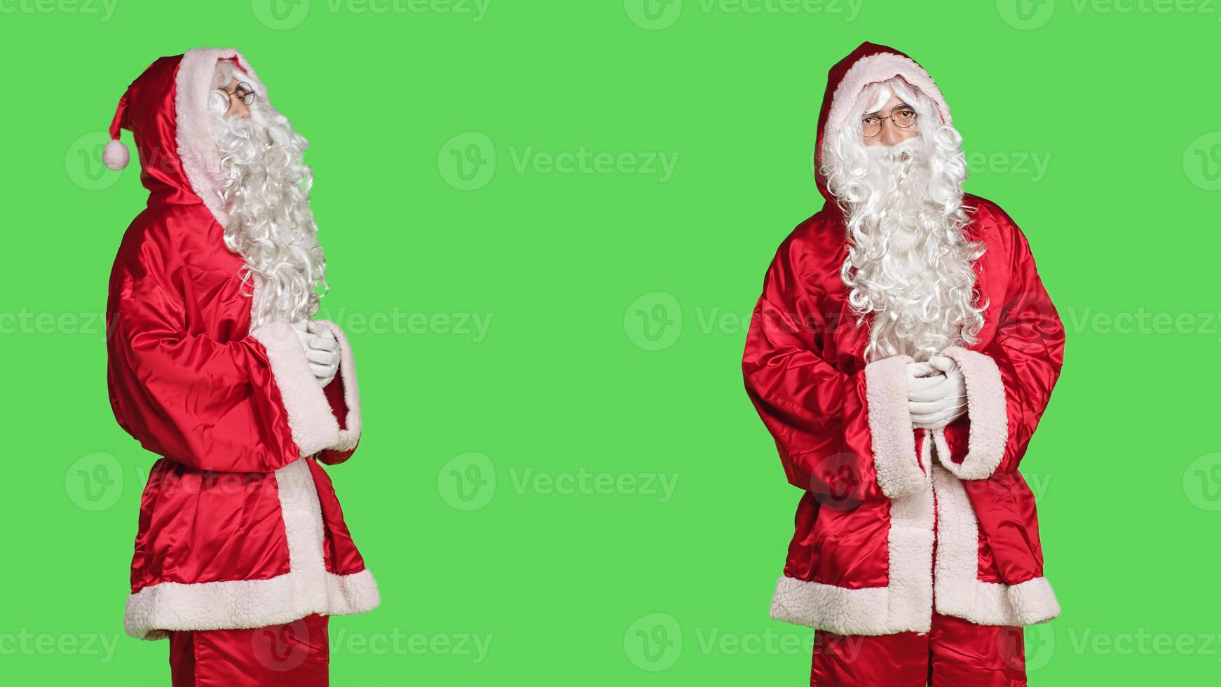 Joyful person in festive red suit acting like santa claus, spreading christmas spirit on greenscreen. Happy man portraying festive seasonal character with traditional costume, hat and beard. photo