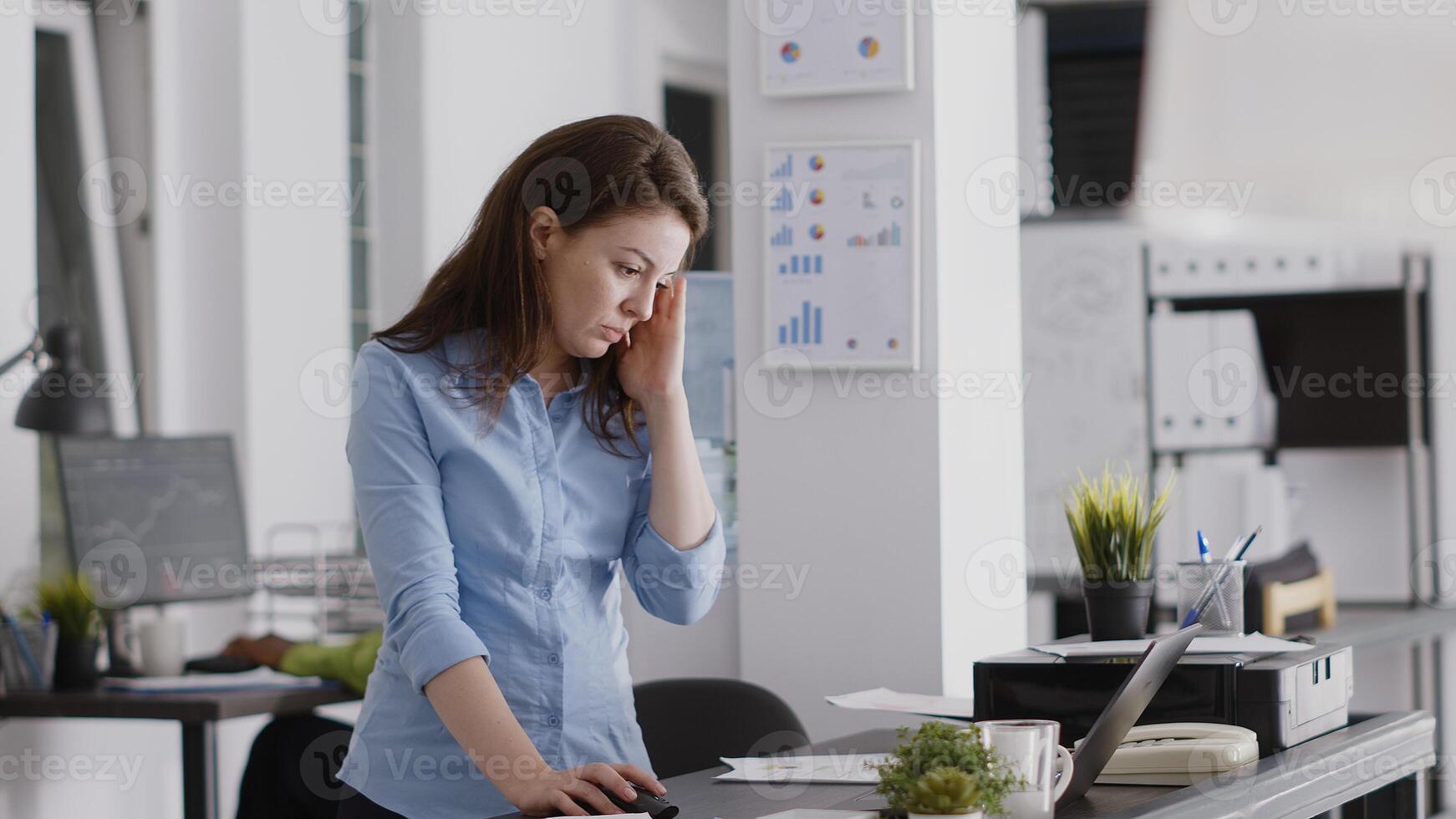 Young employee dealing with headache and working on computer, rubbing temples and feeling worried about pain. Female entrepreneur having painful migraine at desk, work under pressure. photo