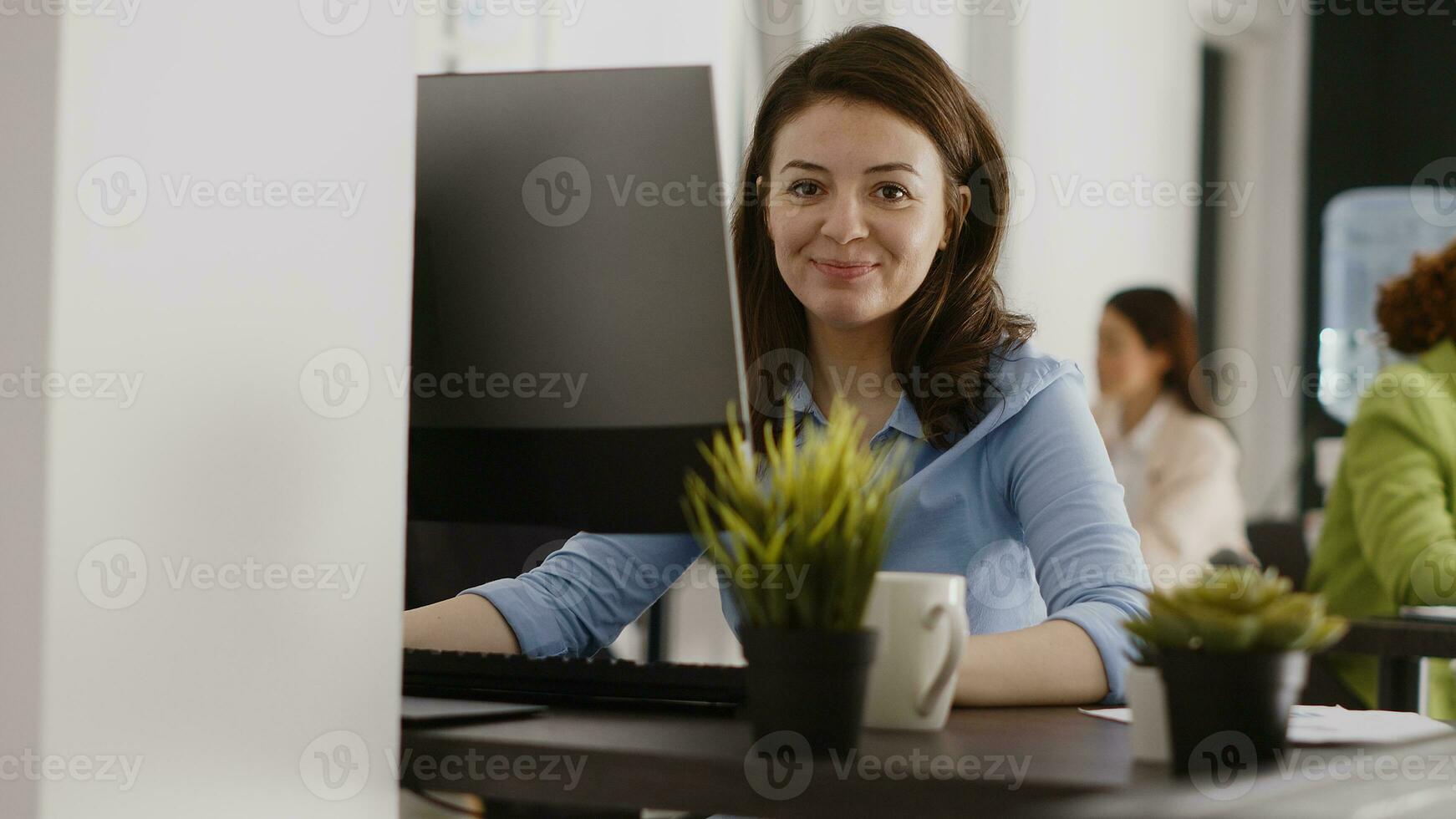 Agency employee working in corporate office with pc, analyzing online data statistics on computer screen. Young entrepreneur looking at company results and analytics. Handheld shot. photo