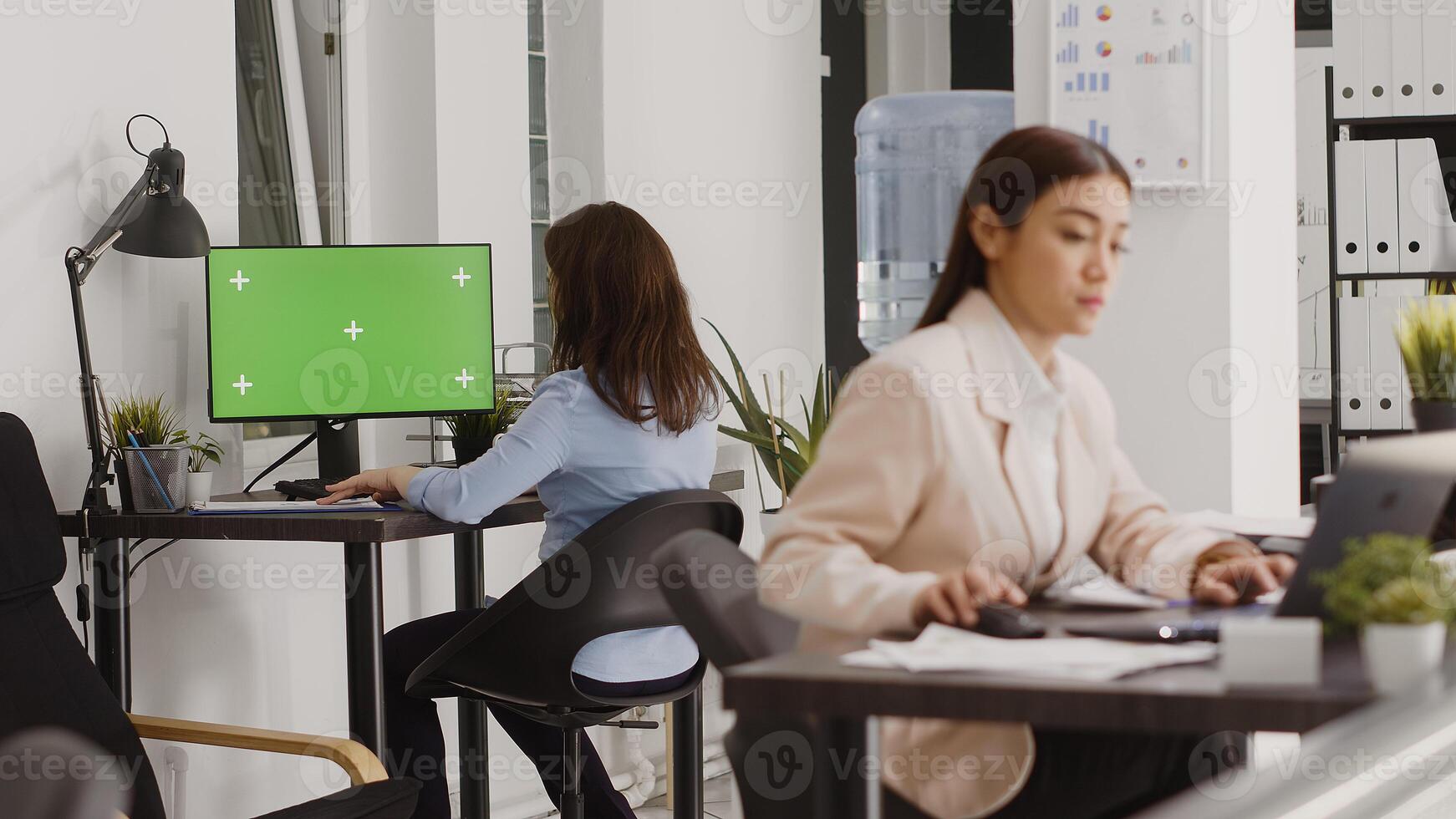 Business manager analyzing greenscreen display on pc, chekcing isolated copyspace on computer in coworking space. Employee using blank mockup template on screen, agency office. photo