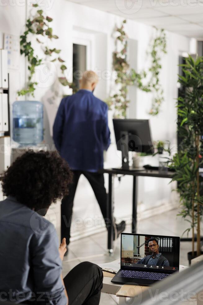 Project manager discussing team performance with executive during videocall on laptop screen. Business employee talking with startup entrepreneur in online meeting in office photo