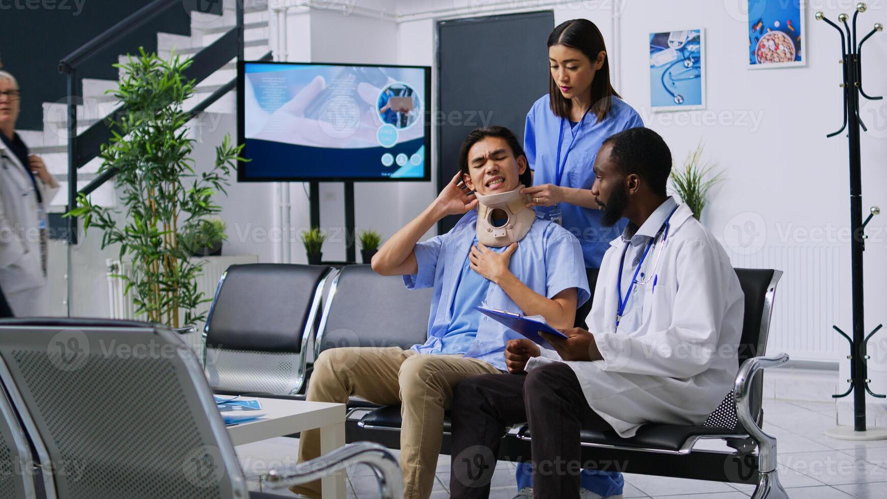 Medical staff helping injured patient to take off cervical collar while trying to recovery after neck fracture. Asian man attending checkup visit consultation in hospital reception. Medicine concept photo