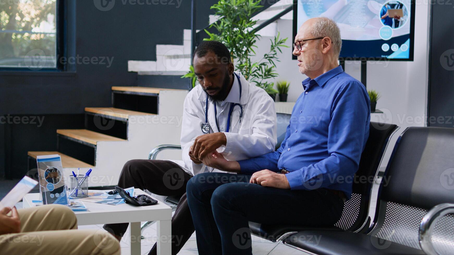 Medic doing insulin level measurement with instrument to help senior man with diabetes, using glucometer to check glucose and sugar from blood. Patient attending checkup consultation in hospital lobby photo