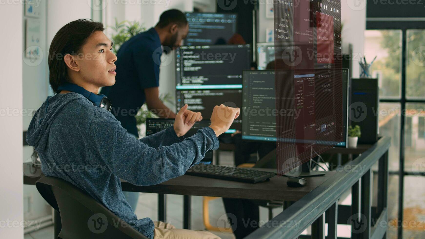 Trained developers helped by AR technology to visualize script in multiethnic office, writing code lines on computer using Java programming languages. Coworkers securing company data photo